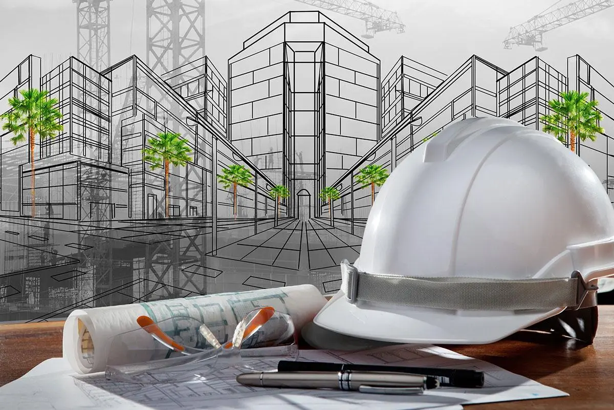 Composición que representa la fase de planificación y desarrollo en arquitectura con un casco de seguridad, planos y un sitio de construcción en el fondo.